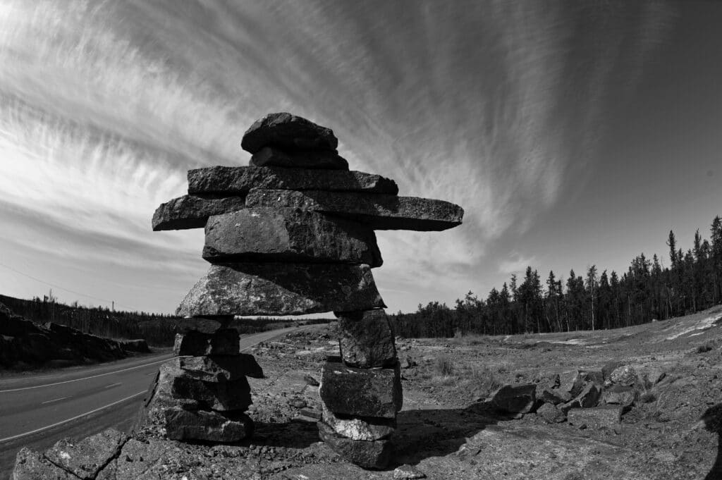 A black and white photo of an inukshuk.