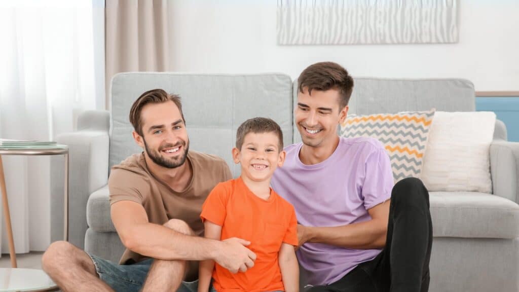 An adoptive family: two das and a young boy.