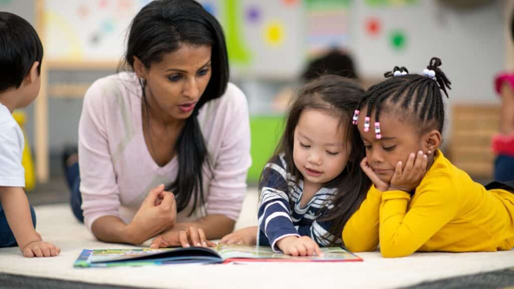 Preschool teacher reading with students