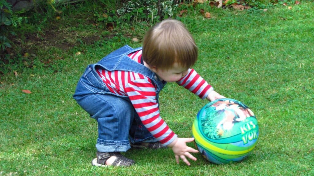Toddler playing with a ball outside