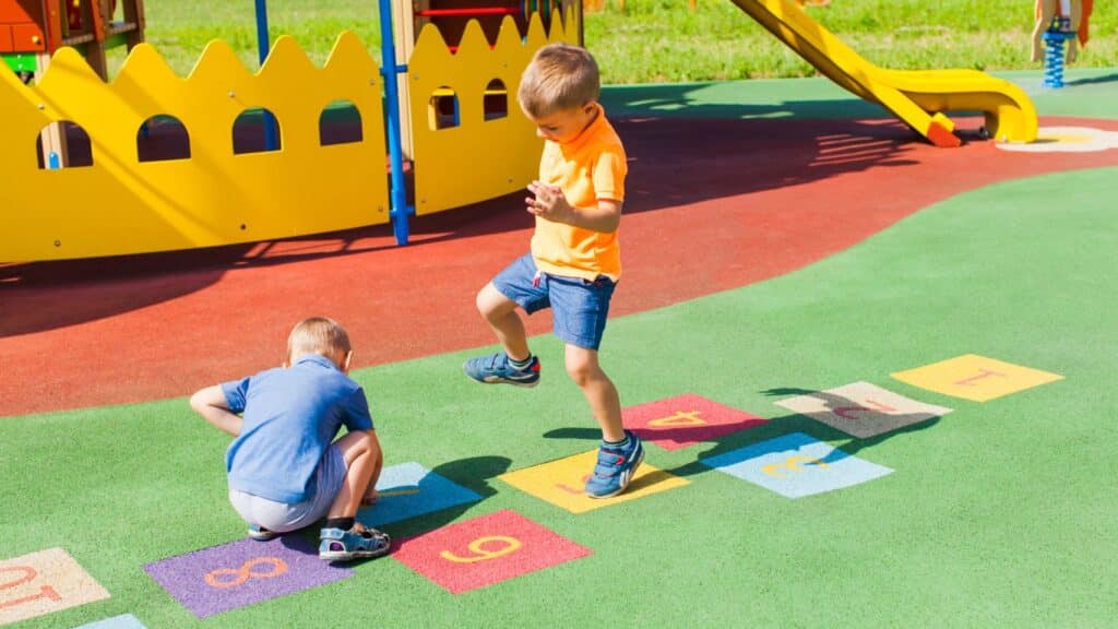 Two boys playing hopscotch outdoors