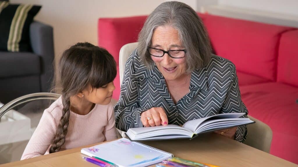 A grandmother helping her grandchildren with her studies